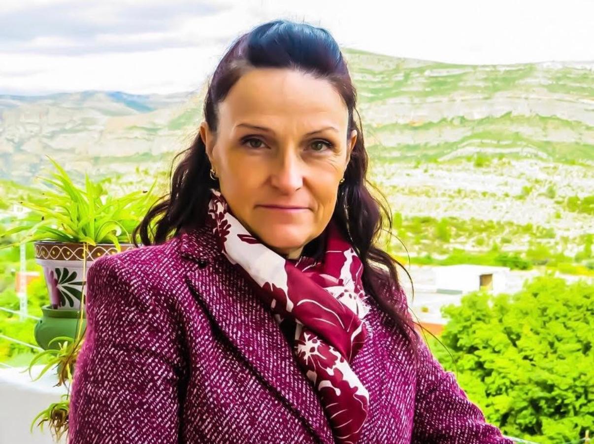 Mujer usando bufanda artesanal de tonos tierra en un ambiente natural